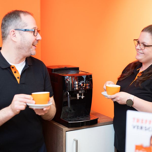 Zwei Mitarbeitende von Robin Look am Kaffeeautomaten – familiäres Arbeitsklima und Wertschätzung im Optiker-Job